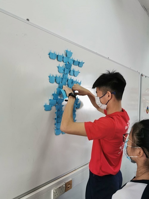 Students busy decorating the white board using the origami Ox